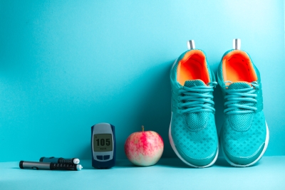 Bild: Sportschuhe neben Apfel neben Diabetesanalysegerät